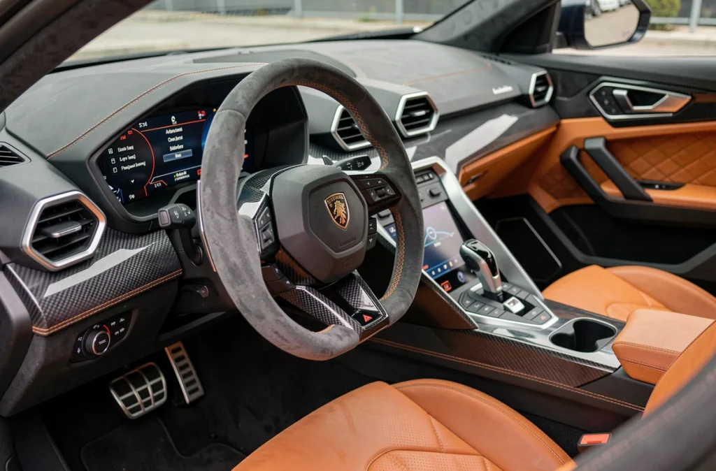 Intérieur luxueux du Lamborghini Urus avec tableau de bord carbone et sièges en cuir surpiqué